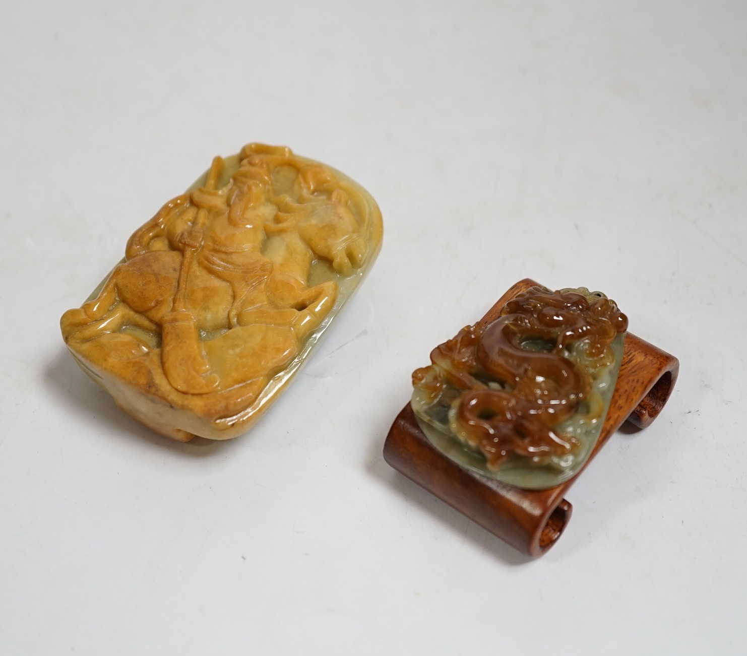 A Chinese jadeite belt buckle and a plaque carved with a dragon, largest 6.5cm high. Condition - good